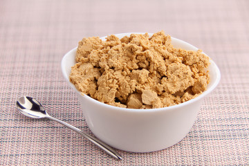 Tasty fresh grained cottage cheese on a plate on  wooden table