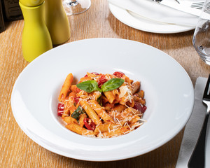 Pasta penne Napoli, traditional italian cuisine dish, chili, tomato and parmesan sauce