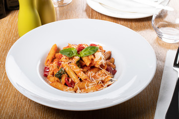 Pasta penne Napoli, traditional italian cuisine dish, chili, tomato and parmesan sauce