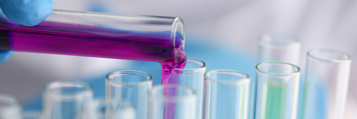 A male chemist holds test tube of glass in his hand overflows