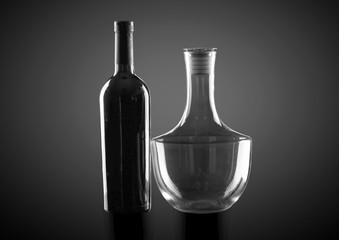 Bottle of wine and decanter on dark background