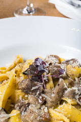 Fresh pappardelle pasta with porcini mushrooms and truffle scent. Parmesan and mozzarella cheese