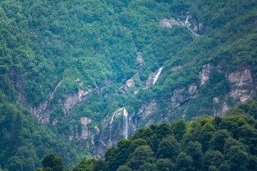 Green mountains with a high waterfall in spring or summer