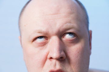 Portrait of a bald man who bulged his eyes.