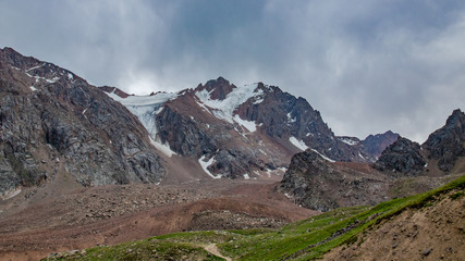 andscape of high rocky mountains with glacier snow-capped peaks and people watching this beauty