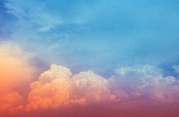 Yellow and red pink color light in fluffy clouds with dim blue sky