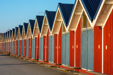 Long row of small, red storage houses with blue doors