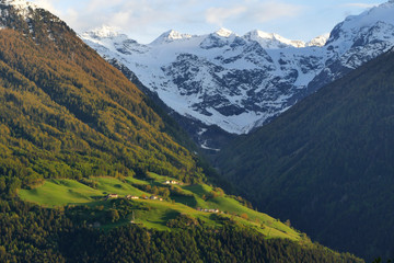 Panorama view of mountain village with meadows underneath glaciers, Venosta Valley, Italy