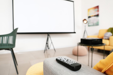 Remote control on sofa in room with video projector
