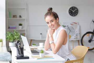 Young woman with laptop working at home