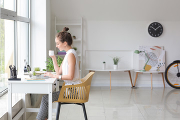 Young woman with laptop working at home