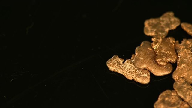Rotating gold nugges (close up footage; selective focus)