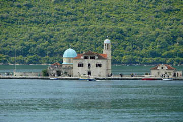 Lady of the Rocks artificial island with church full of tourists inside Bay of Kotor (Boka...