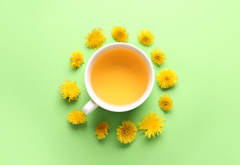 Cup of healthy dandelion tea on color background
