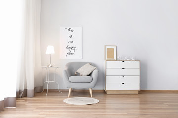 Comfortable armchair and chest of drawers in interior of living room