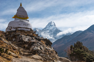 White traditional Tibetan stupa in front of Ama Dablam mountain peak in Everest base camp trekking...