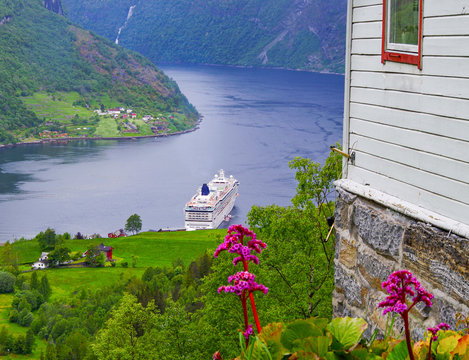 Breathtaking landscape scenery in Geirangerfjord while cruising on NCL Norwegian Cruise Line cruiseship to Geiranger in Norway during Norwegian cruising in summer on vacation and holiday with blue sky
