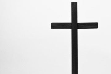 Crucifix is a monochrome isolated image of a dark holy cross with a white background. The crucifix is a sacred religious symbol.