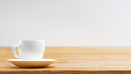 White cup of coffee espresso on wooden background. Shallow focus. Front view with copyspace.