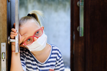 Little child looking unhappy and depressed after staying at home due banned street activity. Kid wearing medical face masks go out for outside walk, ending coronavirus Covid-19 disease quarantine.