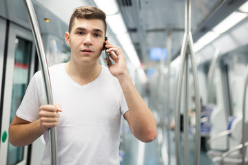 Fototapeta na wymiar Man traveling on subway and talking on smartphone
