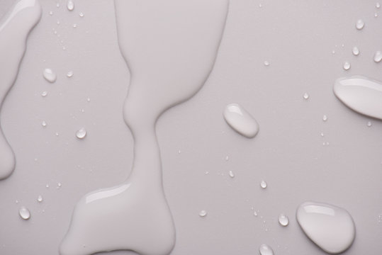 Close-up photo of water and drops on light grey white background
