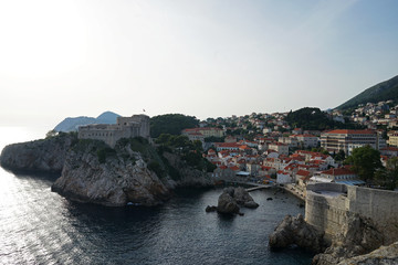 Fototapeta premium Exterior architecture and design of Dubrovnik old town city walls and landscape with clear blue sky, southern Croatia fronting the Adriatic sea encircled with massive stone