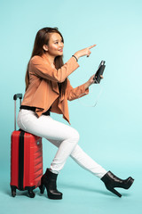 asian woman travel with red hard case bag holding passport and smart phone for flight check in