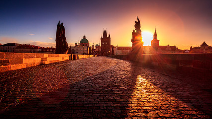 Charles Bridge with statues at sunrise in Prague