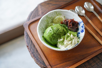 Dark Matcha ice cream. A plate of matcha ice cream scoop served with red bean, whipping cream and Japanese dango. (top view)