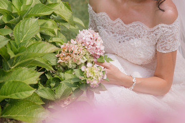 bride with a bouquet of flowers in the park