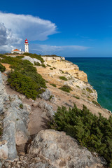 Fototapeta na wymiar Farol de Alfanzina, a lighthouse near Carvoeiro at the southern coast of the Algarve, Portugal.