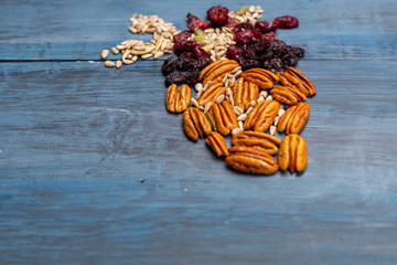Nuts in the shape of a human heart with walnut, raisins, pumpkin seeds, dried cranberries