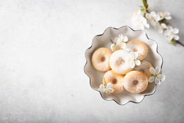 donuts in a vintage vase with cherry flowers on a light background