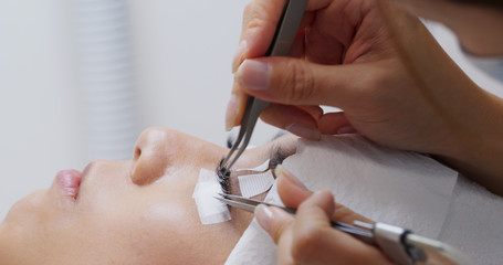 Woman with eyelash extension in beauty salon