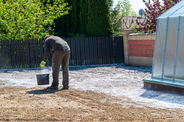 man adds lime to the clay