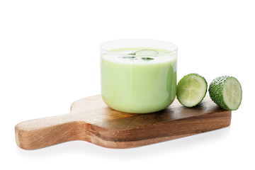 Glass with cold cucumber soup on white background