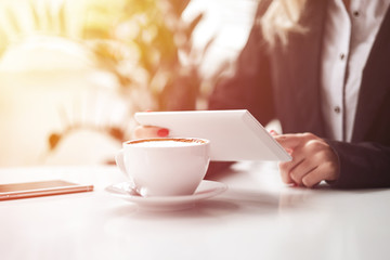 Business woman hands using smart phone and cup of coffee.