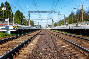 Obraz premium Railway track with platforms at a provincial station. Metallic rails and sleepers. Travel and tourism. Background. Space for text.