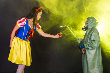 Danger, nuclear and radiation measurement - Girl holds apple with radiation hazard symbol.
