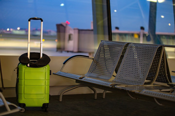Suitcase with a pillow at the airport on the background of the runway
