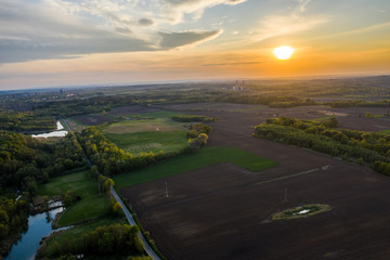 Fototapeta na wymiar aerial view of sunset over field and forests