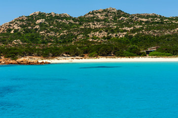 A view from a yacht of the crystal clear and colorful sea of ​​Budelli island with its famous and protected pink beach on a sunny day, in Budelli island Sardinia Italy
