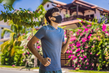 Man runner wearing medical mask. Running in the park. Coronavirus pandemic Covid-19. Sport, Active life in quarantine surgical sterilizing face mask protection. Outdoor run on athletics track in