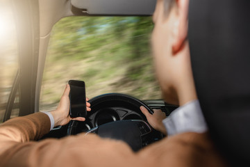 Point of view driver man using smartphone. Violation traffic rules and laws. Dangerous driving. Blurred background.