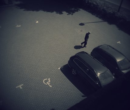 High Angle View Of Man Walking By Car In Parking Lot