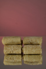 Semi-finished products. Filled Frozen Pancakes. On a mirror background. Isolates.