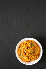 Homemade Chicken Tikka Masala in a white bowl on a black background, top view. Flat lay, overhead, from above. Copy space.