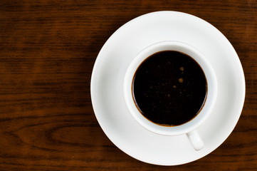 White coffee cup and coffee beans on a wooden table.Coffee time