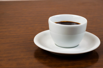 White coffee cup and coffee beans on a wooden table.Coffee time